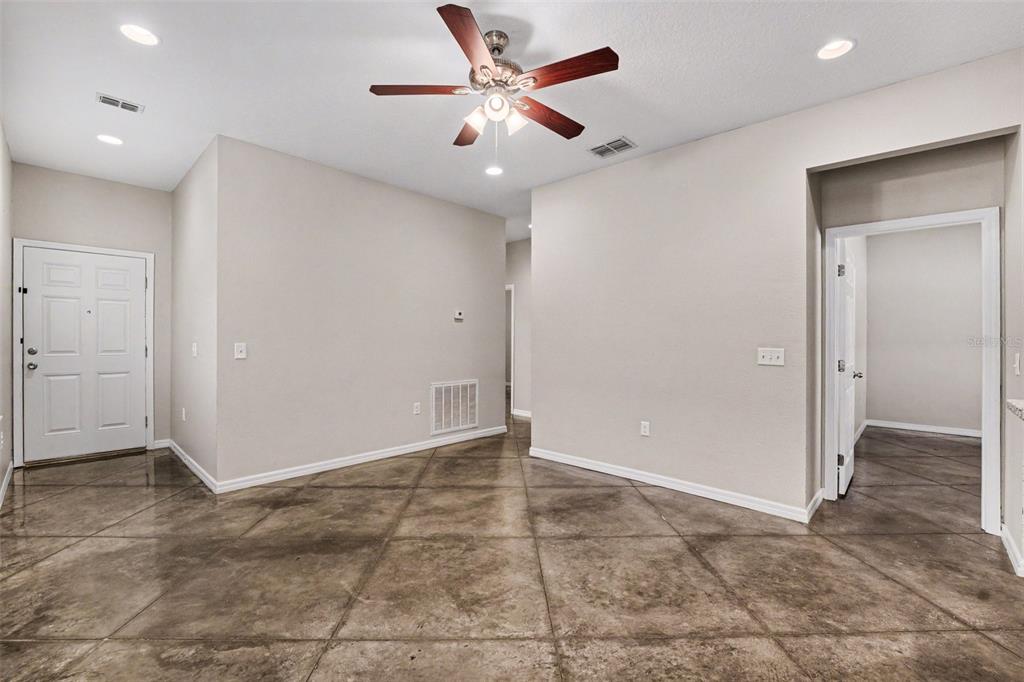 An interior view of an entryway with stained concrete floors, a ceiling fan, and recessed lighting — 2865 WHISPERING TRAILS DRIVE, WINTER HAVEN, FL