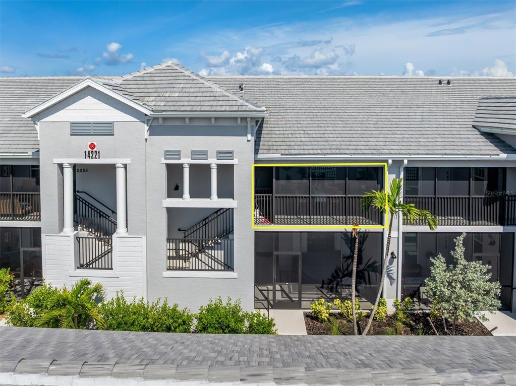 An exterior view of a multi-story building featuring a screened-in balcony highlighted by a yellow box — 14221 HERITAGE LANDING BOULEVARD UNIT 2026, PUNTA GORDA, FL