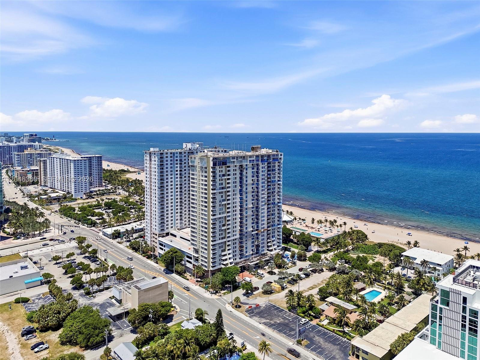 An aerial view shows high-rise apartment buildings situated along a sandy beach and ocean — 111 N BRINY AVE, Pompano Beach FL 33062, POMPANO BEACH, FL