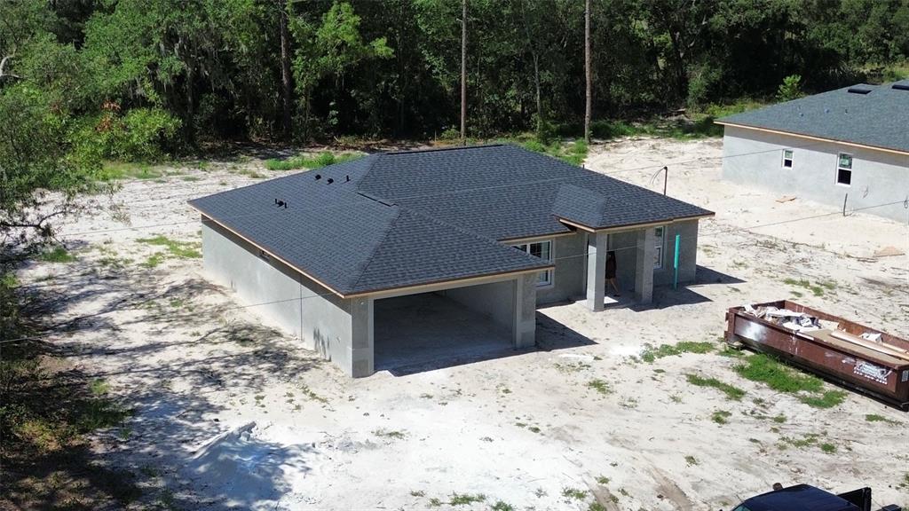 An aerial view of a newly constructed single-story house with a dark shingled roof — 6164 SW 144TH LANE ROAD, OCALA, FL