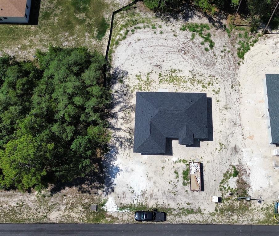 An aerial view shows a new house under construction on a sandy, partially wooded lot — 6164 SW 144TH LANE ROAD, OCALA, FL