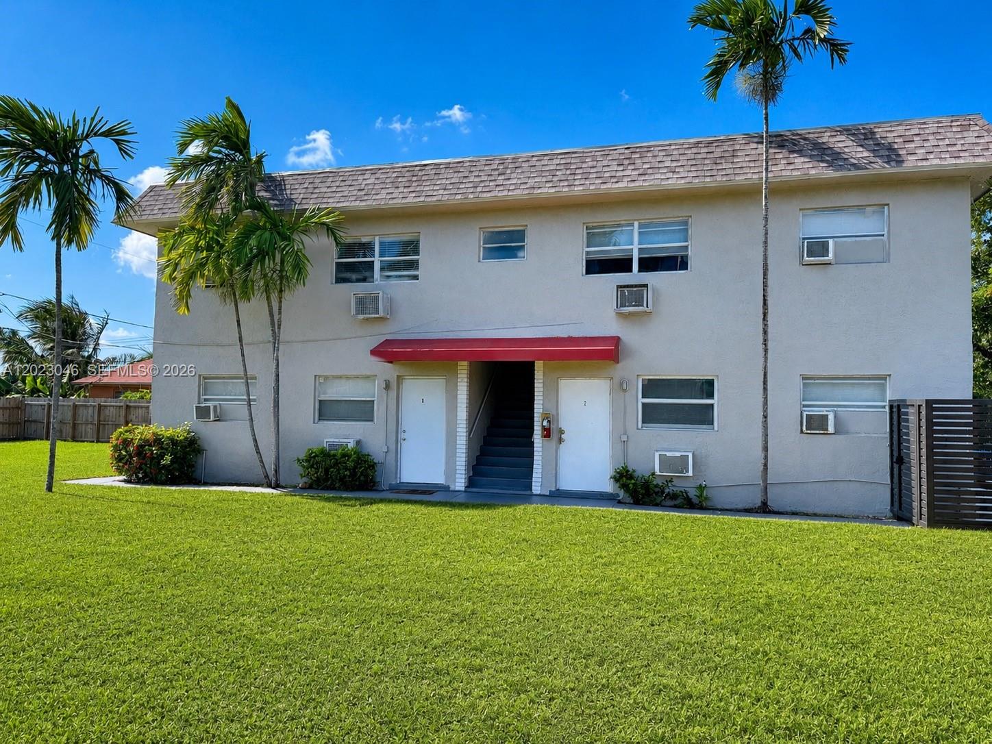A two-story apartment building features a red awning over the central entrance and stairs — 811 NW 6th Ave # 4, Pompano Beach FL 33060, POMPANO BEACH, FL