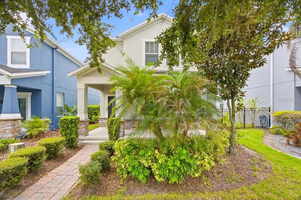 A two-story house with a stone-accented front porch, a palm tree, and a brick walkway — 11854 SONNET AVE, ORLANDO, FL