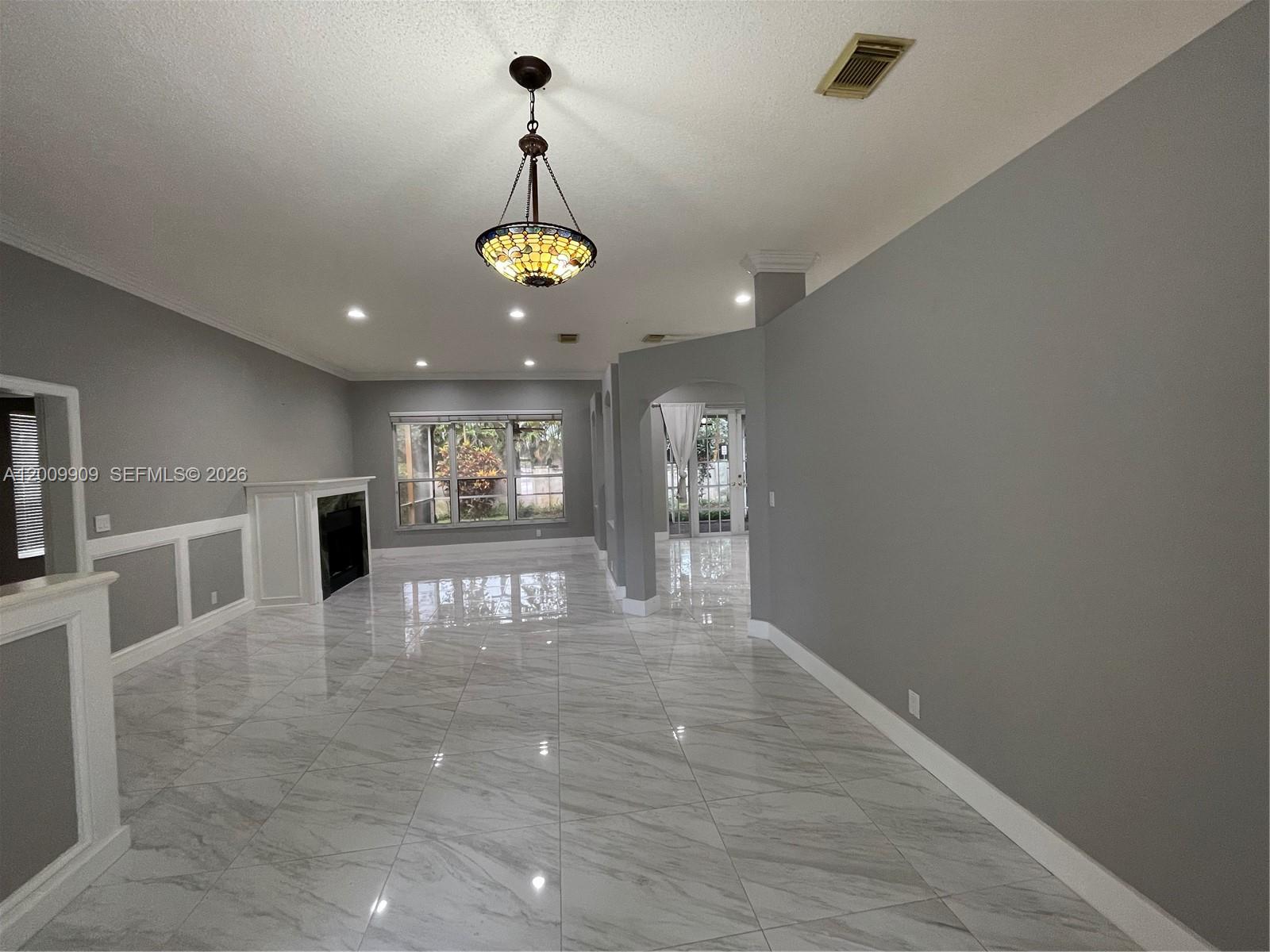 A living room features gray walls, white wainscoting, a fireplace, and light-colored marble tile flooring — 5263 SW 34th Way, Hollywood FL 33312, HOLLYWOOD, FL