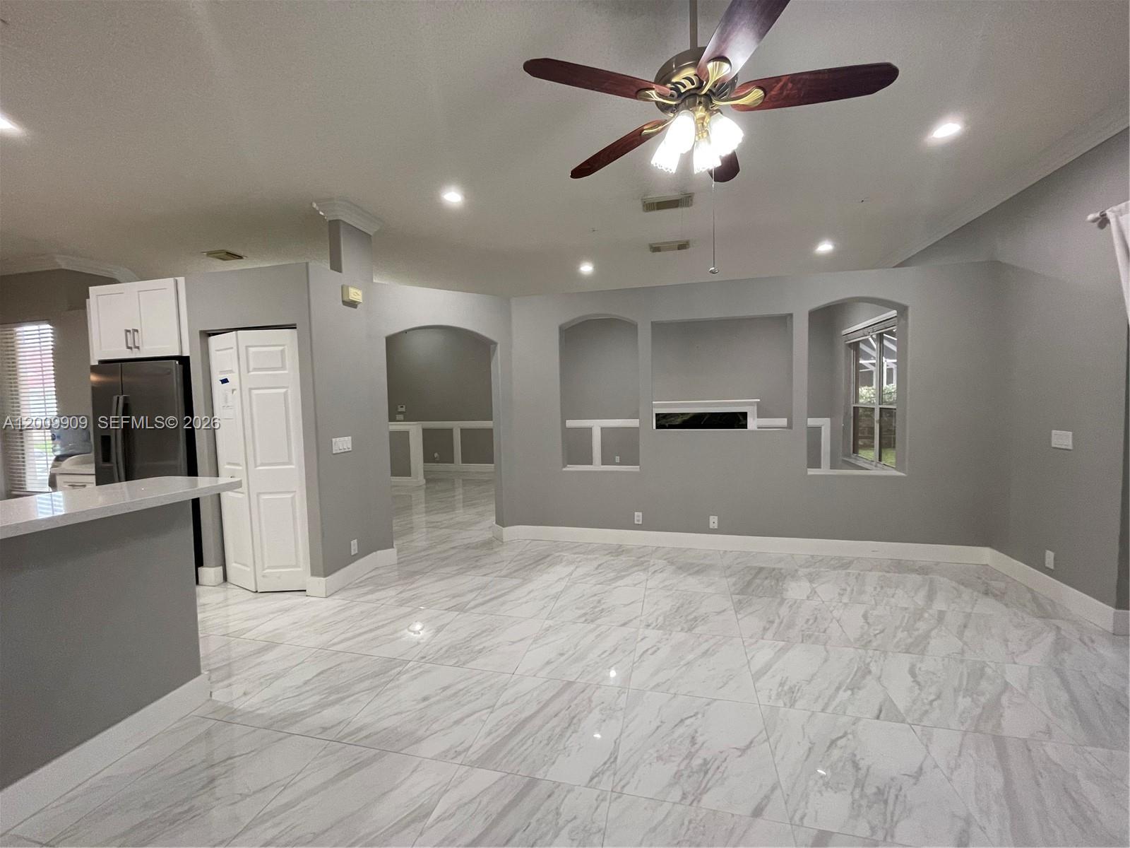 A living room features gray walls, white tile flooring, a ceiling fan, and built-in wall niches — 5263 SW 34th Way, Hollywood FL 33312, HOLLYWOOD, FL