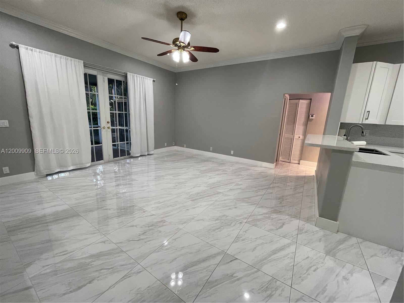 A living area features gray walls, white tile flooring, a ceiling fan, and glass doors — 5263 SW 34th Way, Hollywood FL 33312, HOLLYWOOD, FL