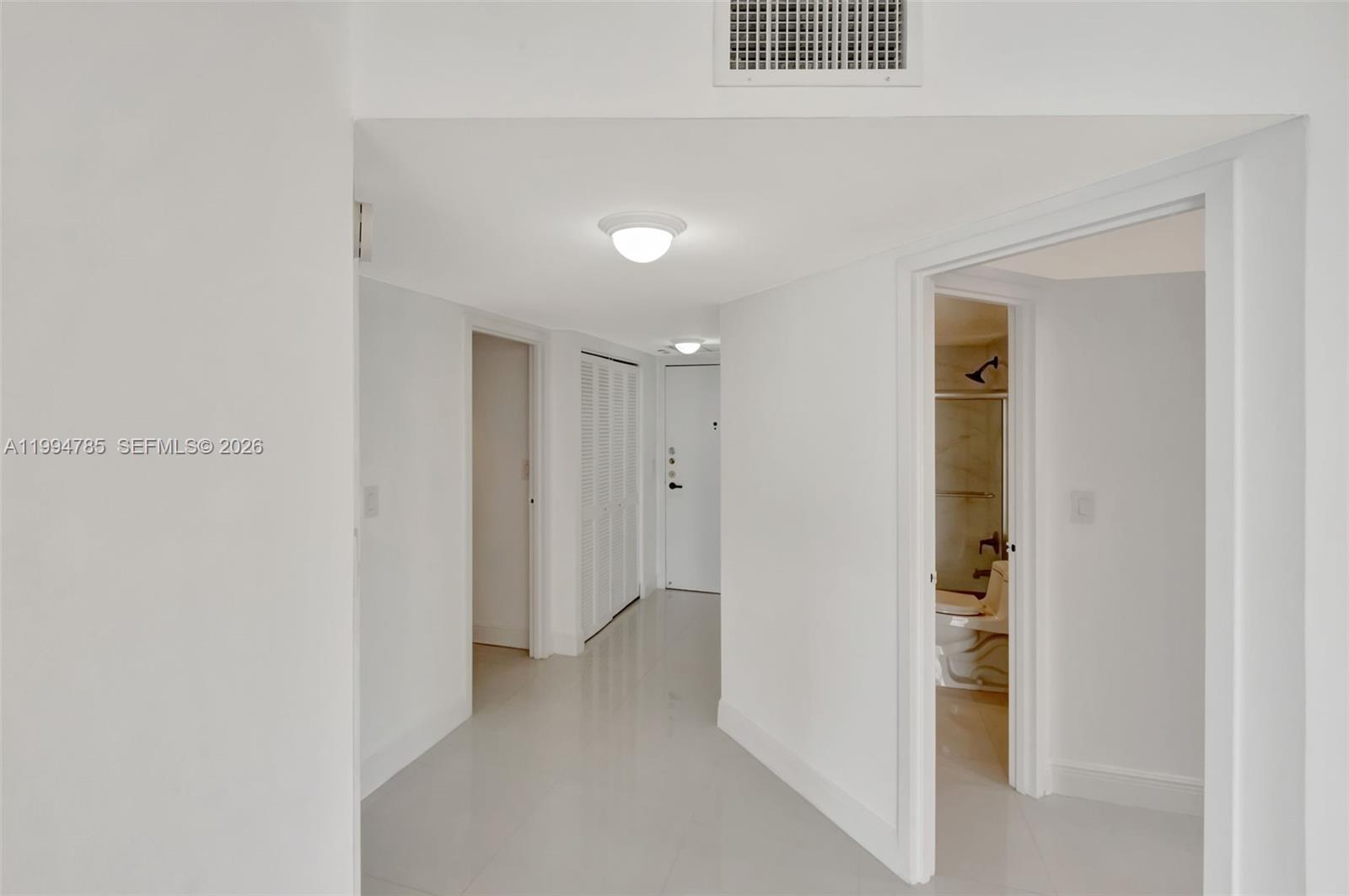 A bright hallway with white walls, tiled floors, and doorways leading to other rooms — 2333 Brickell Ave # 305, Miami FL 33129, MIAMI, FL