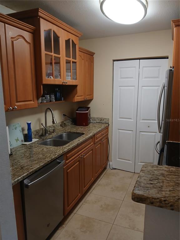 An entryway with tile flooring leads to a doorway opening into a wood-floored room — 455 ALT 19 S UNIT 121, PALM HARBOR, FL