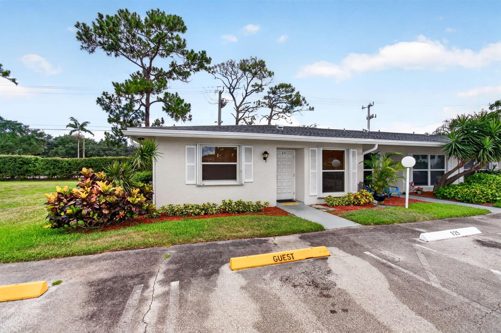 A single-story residential unit with a white exterior, shuttered windows, and a designated guest parking space — 2830 SW 15th Street # a, Delray Beach FL 33445, DELRAY BEACH, FL