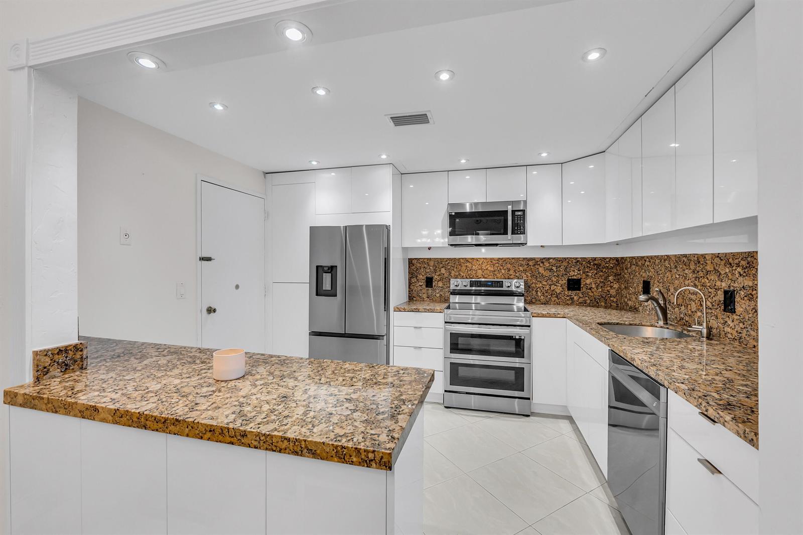 A kitchen features white flat-panel cabinets, granite countertops, stainless steel appliances, and recessed lighting — 2851 S Ocean Boulevard # P, Boca Raton FL 33432, BOCA RATON, FL