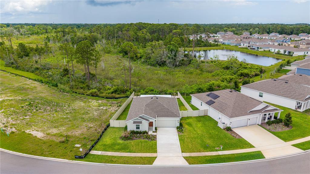 An aerial view shows a suburban house with a driveway and a fenced backyard — 5317 DIAMONDLEAF DRIVE, EDGEWATER, FL