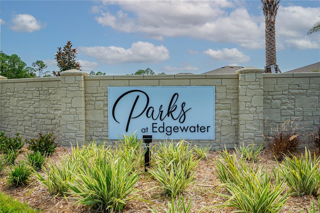 A stone wall features a sign reading Parks at Edgewater surrounded by landscaping — 5317 DIAMONDLEAF DRIVE, EDGEWATER, FL
