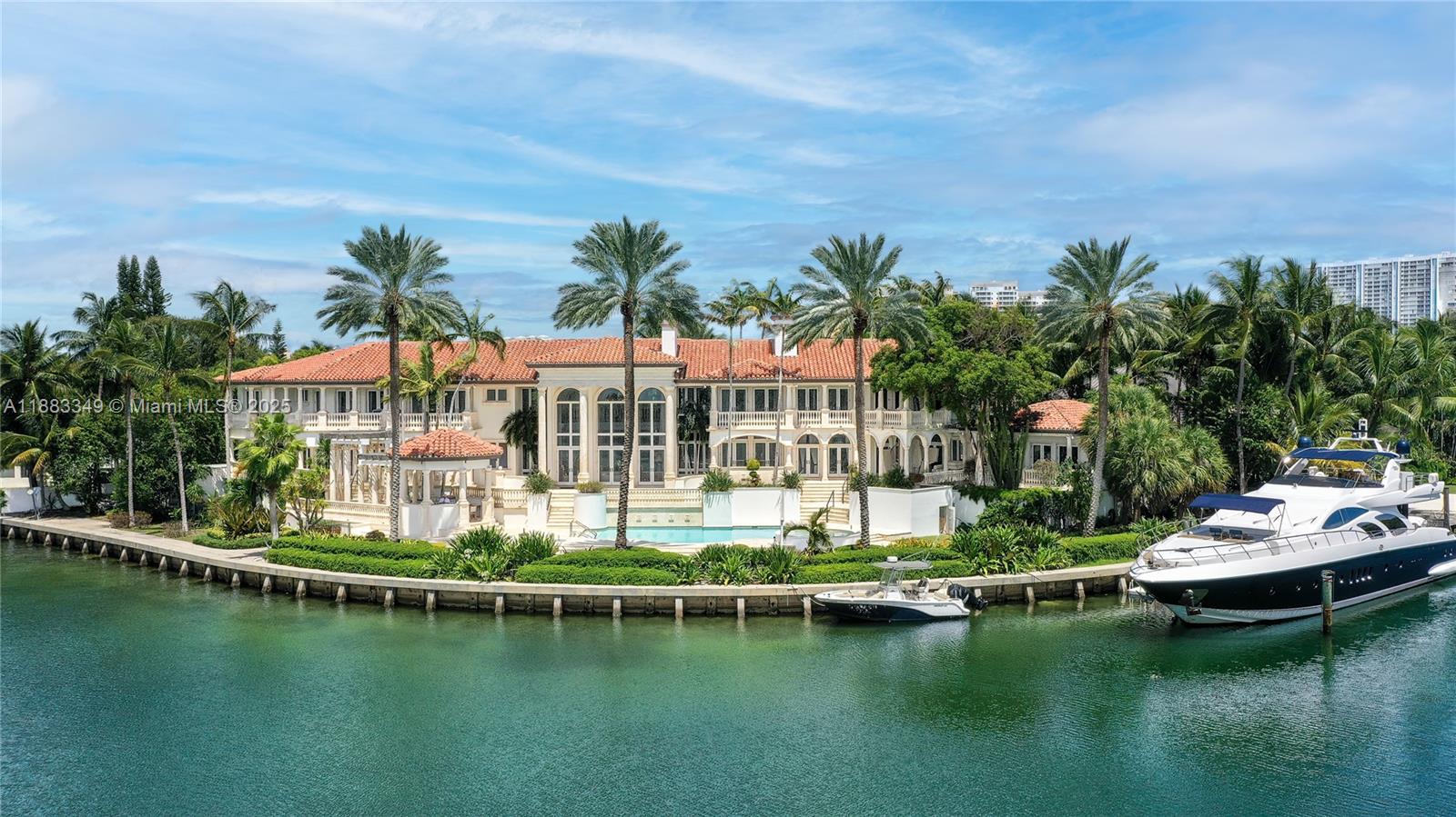 An aerial view shows a large waterfront mansion with a pool, palm trees, and docked boats — 260 Cape Florida Dr, Key Biscayne FL 33149, KEY BISCAYNE, FL