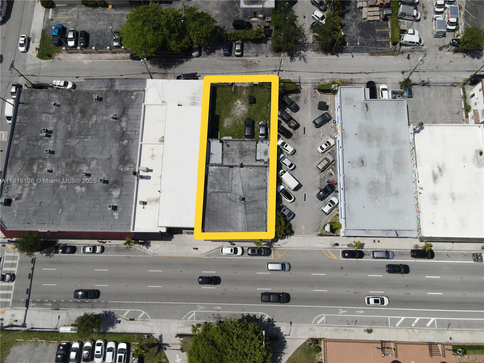 This aerial view shows a rectangular property lot highlighted in yellow between two commercial buildings — 1328 W Flagler St, Miami FL 33135, MIAMI, FL
