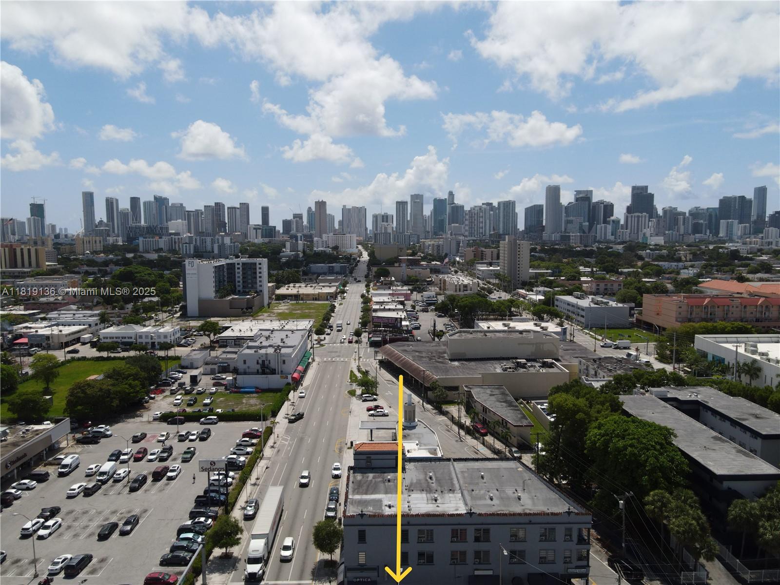An aerial view shows a city street with a multi-story building marked by an arrow — 1328 W Flagler St, Miami FL 33135, MIAMI, FL