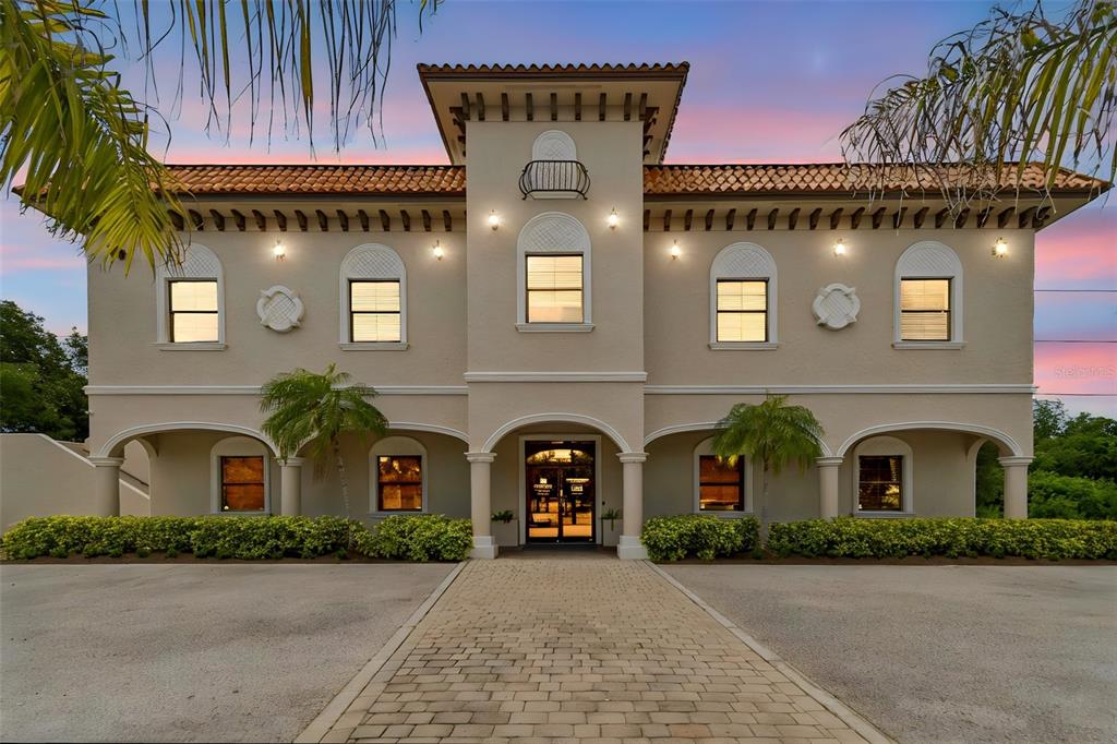 A symmetrical two-story Mediterranean-style building with a tiled roof, arched entryway, and paved walkway — 6730 W LINEBAUGH AVENUE, TAMPA, FL