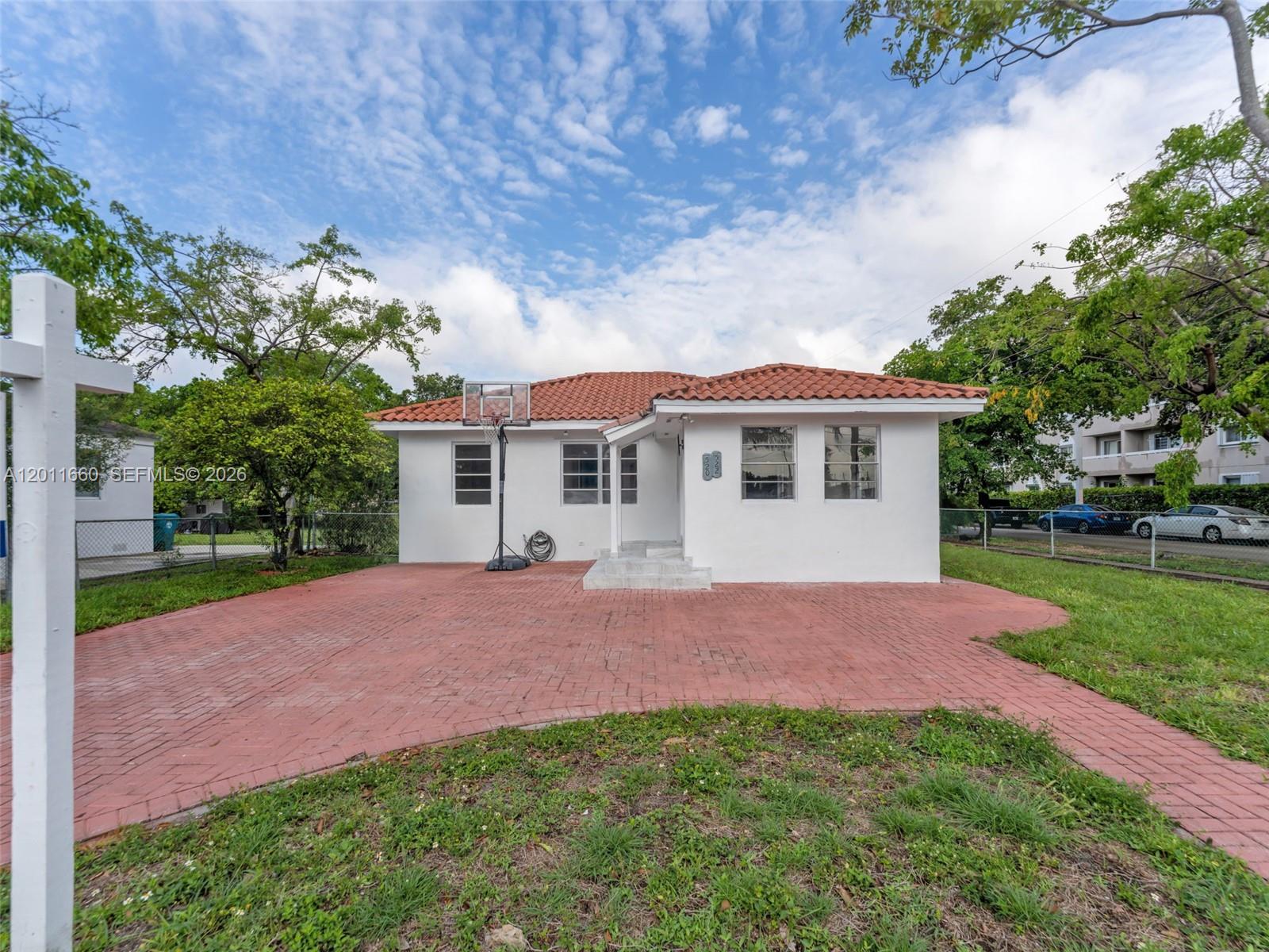 A white single-story house with a red tile roof and a red brick driveway — 520 NW 32nd Pl # 520, Miami FL 33125, MIAMI, FL