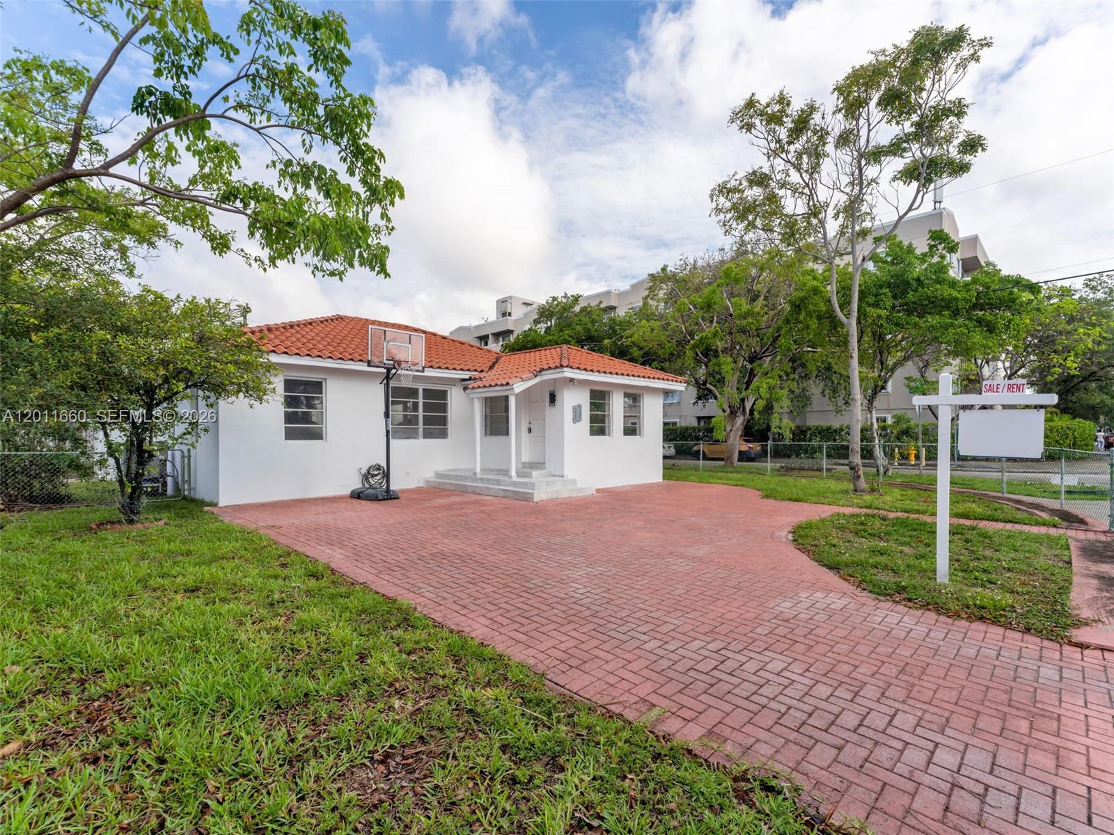 A white single-story house with a red tile roof and a brick driveway — 520 NW 32nd Pl # 520, Miami FL 33125, MIAMI, FL