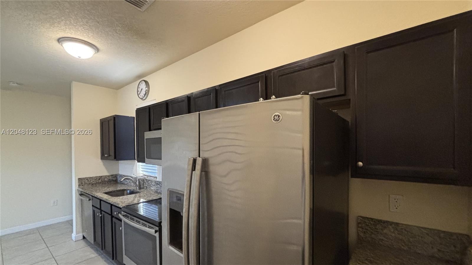 A kitchen features dark wood cabinets, granite countertops, and stainless steel appliances — 17170 SW 93rd St # 0, Miami FL 33196, MIAMI, FL