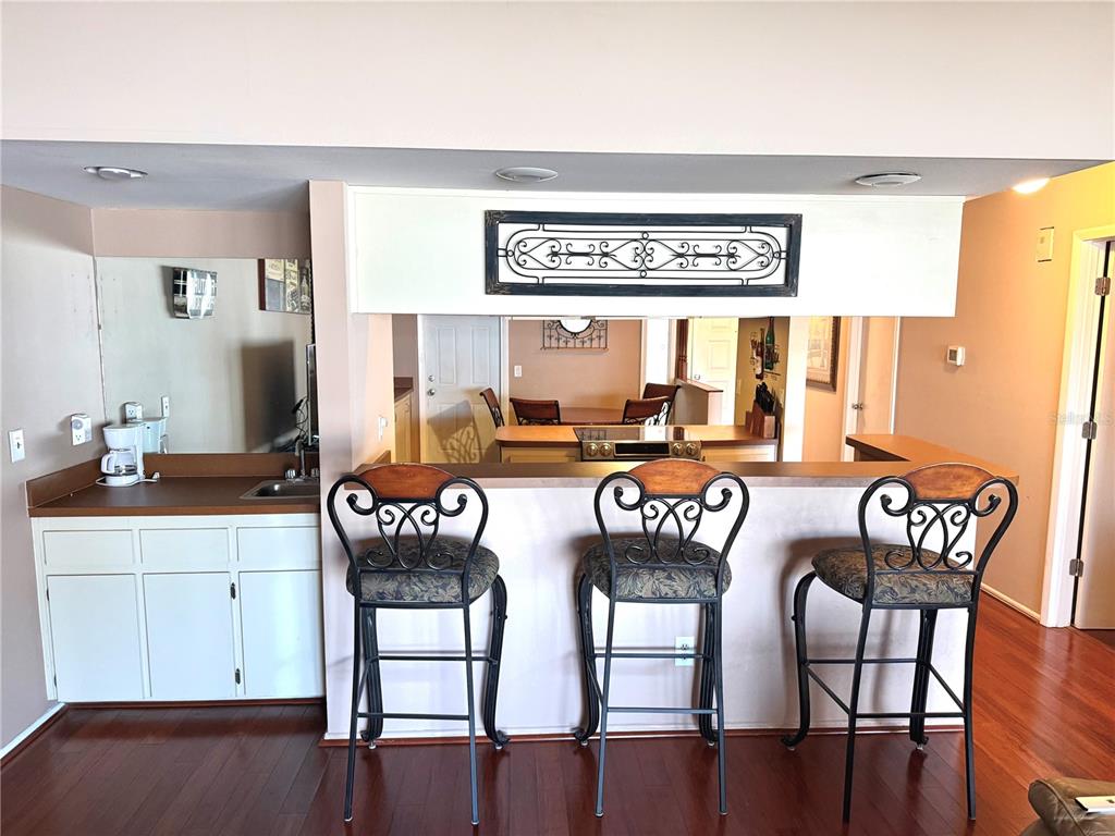 A kitchen features a breakfast bar with three stools and a wet bar area — 2034 MONTEGO COURT, OLDSMAR, FL