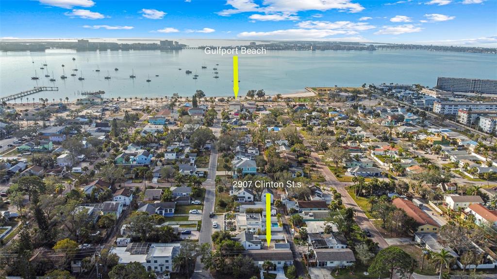 An aerial view shows a residential neighborhood leading to a beach and a large bay — 2907 CLINTON STREET S, GULFPORT, FL