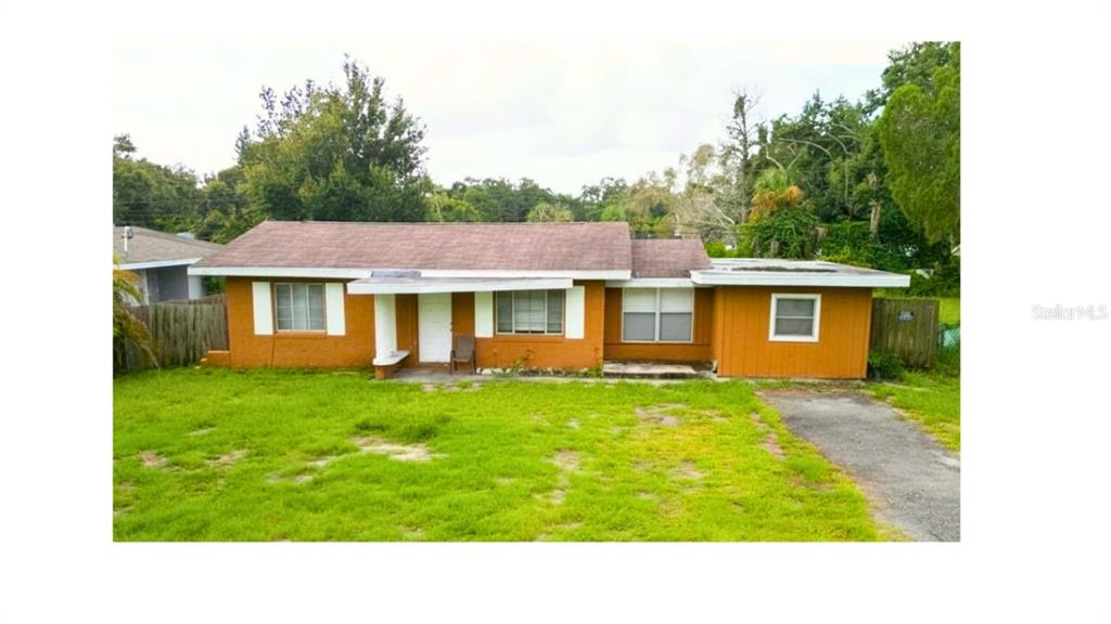 An aerial view of a single-story orange house with a brown shingled roof and yard — 1329 WOODBINE STREET, CLEARWATER, FL