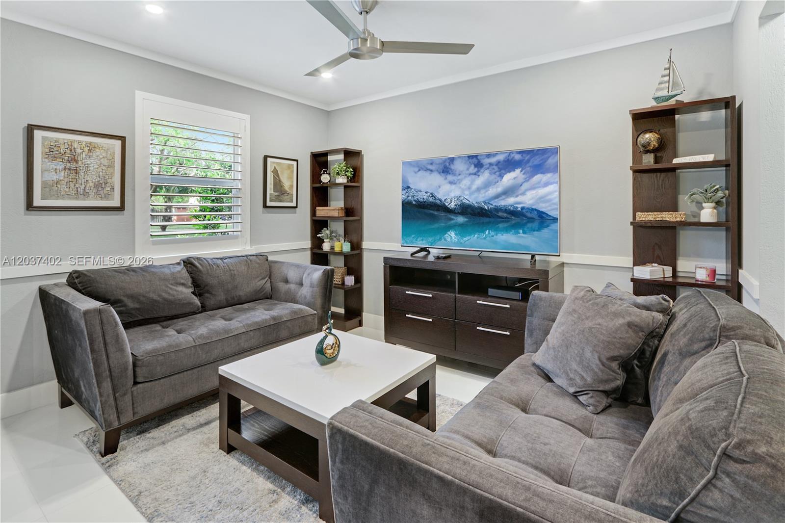 A living room features two gray sofas, a white coffee table, and a television console — 424 NE 27th Dr, Wilton Manors FL 33334, WILTON MANORS, FL