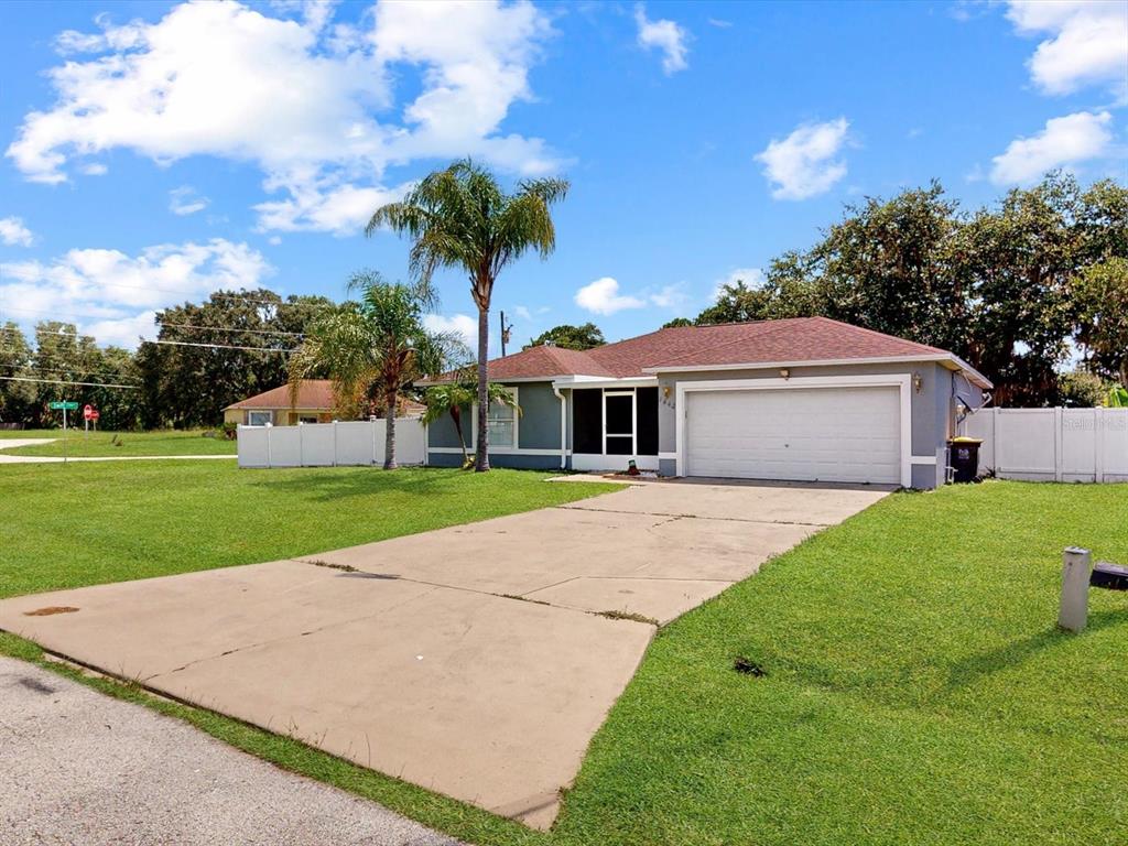 A single-story house with a concrete driveway, a two-car garage, and a palm tree — 1444 SWIFT COURT, POINCIANA, FL