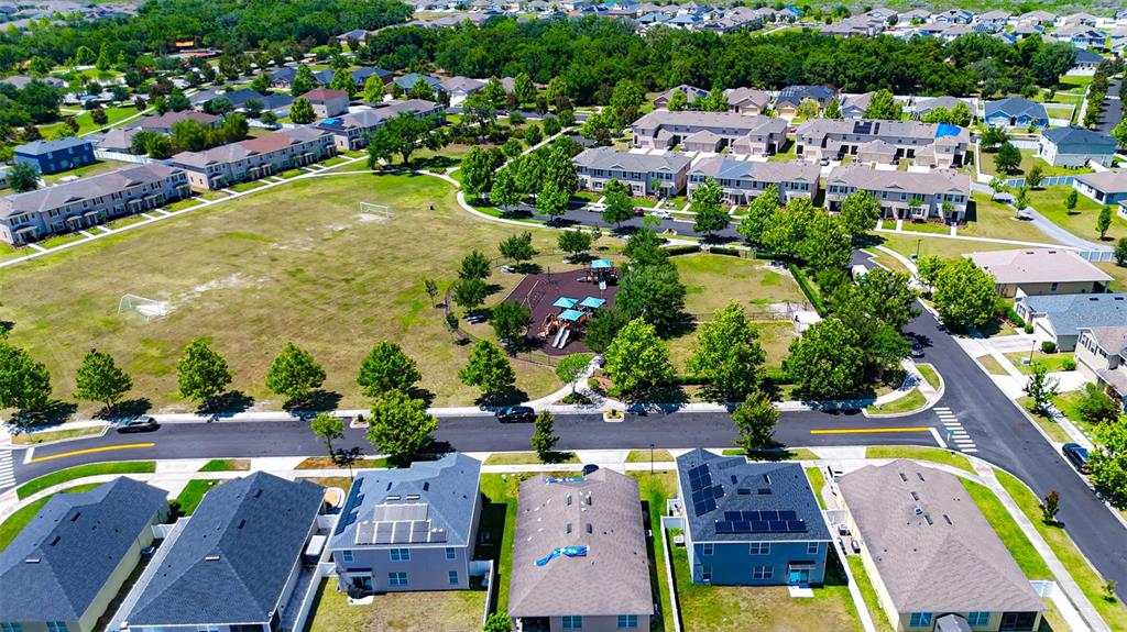 An aerial view shows a residential neighborhood with houses, a park, and a playground — 1957 RED CANYON DRIVE, KISSIMMEE, FL