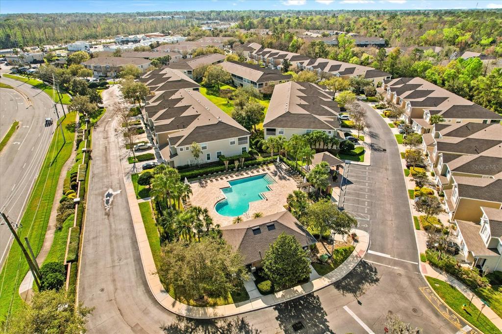 An aerial view shows a residential complex with a central swimming pool and parking areas — 409 HILGARD COVE UNIT 106, SANFORD, FL