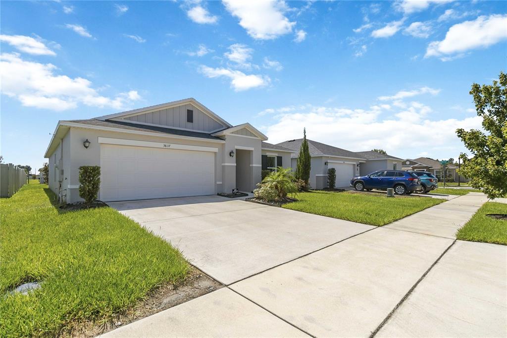A single-story suburban house with a two-car garage and a concrete driveway — 3837 ELK BLUFF ROAD, ST CLOUD, FL