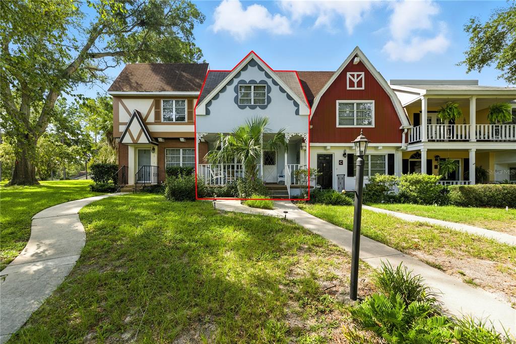 A light blue townhouse with a front porch sits between two other multi-story residential buildings — 9951 SW 88TH COURT ROAD UNIT B, OCALA, FL