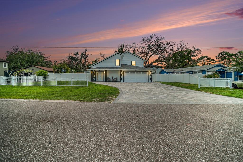 A two-story house with a paved driveway, white vinyl fence, and a two-car garage — 8502 MAY STREET, TAMPA, FL