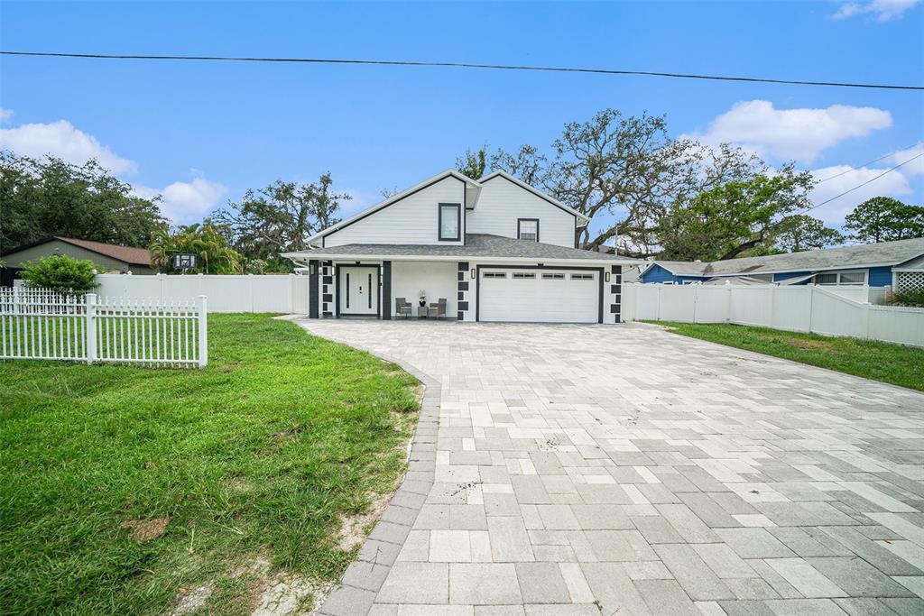 A two-story white house features a paved driveway, a two-car garage, and a white fence — 8502 MAY STREET, TAMPA, FL