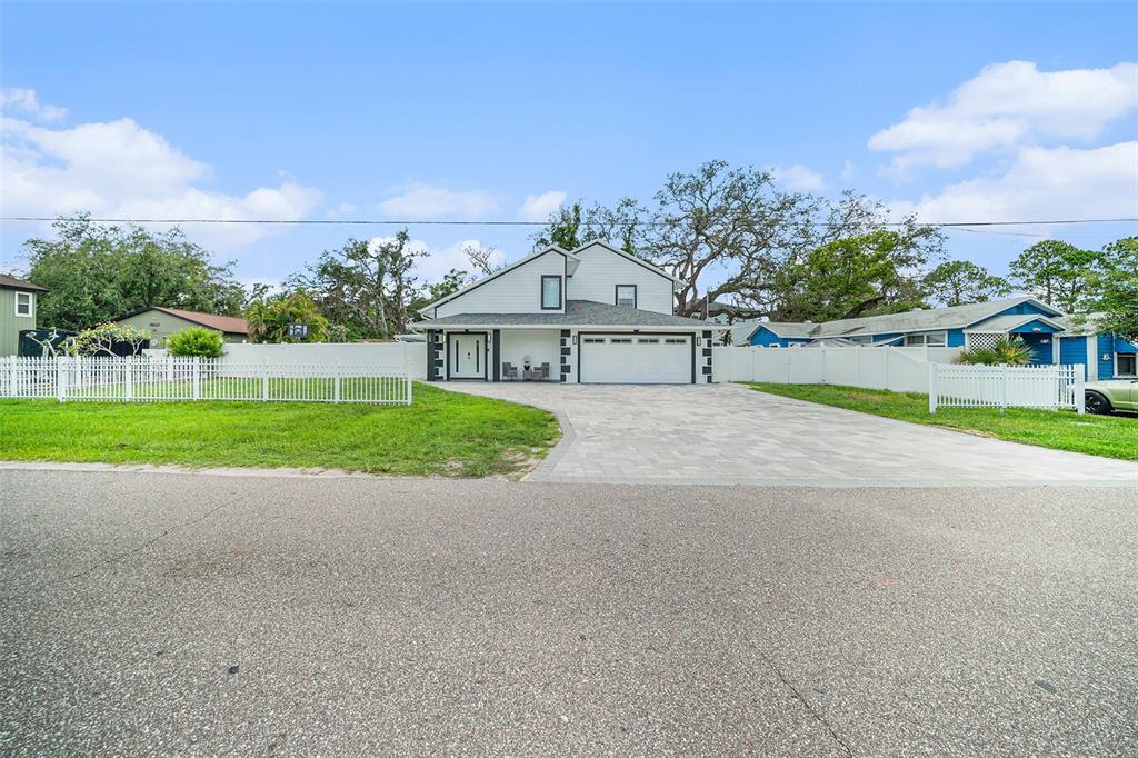A two-story house with a white exterior, a paved driveway, and a white picket fence — 8502 MAY STREET, TAMPA, FL