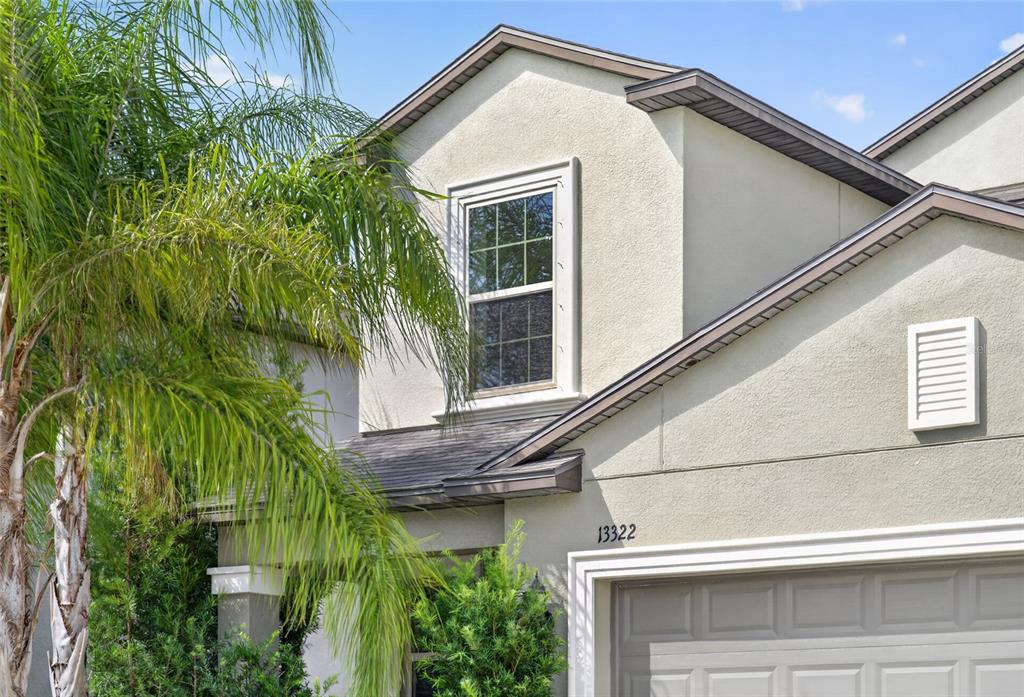A two-story house with a gray garage, red front door, and a palm tree — 13322 MARBLE SANDS COURT, HUDSON, FL