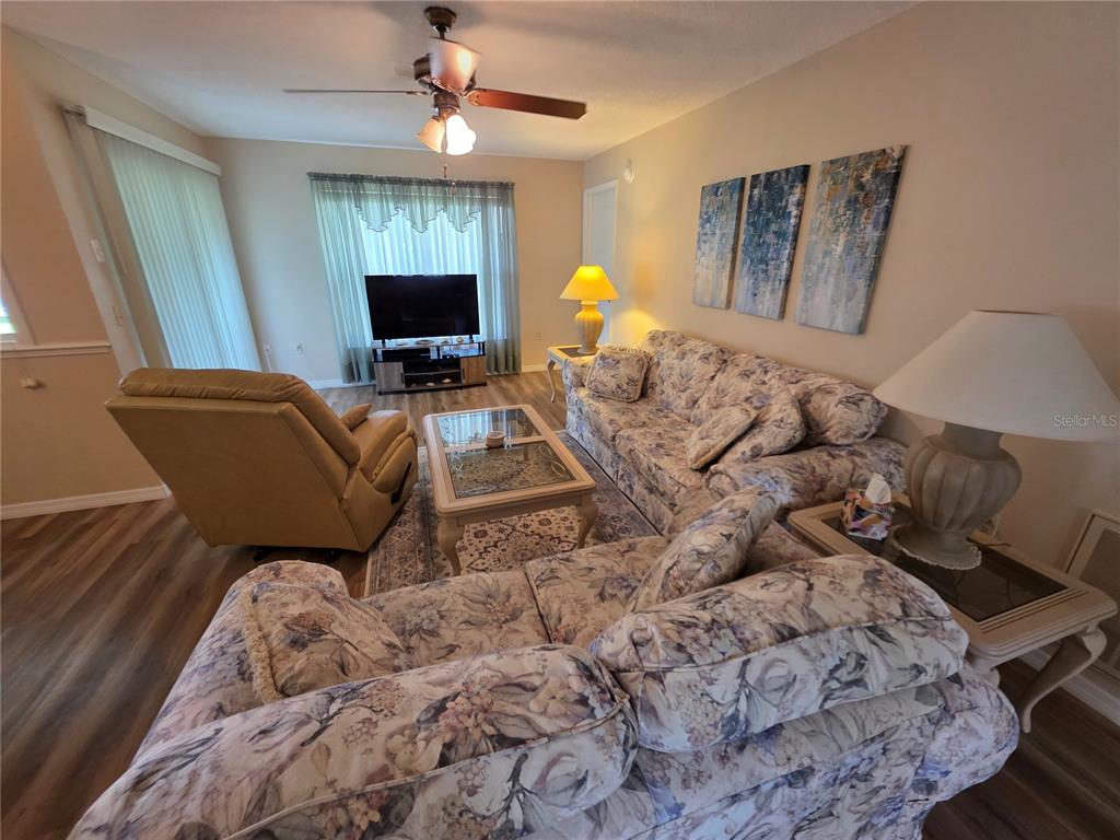 A living room features floral sofas, a recliner, a coffee table, and a ceiling fan — 6234 GLEN EAGLES COURT, SPRING HILL, FL