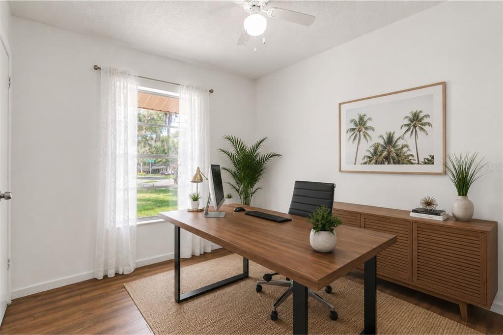 A home office features a wooden desk, a black chair, and a palm tree print — 1124 GRANT AVENUE, MOUNT DORA, FL