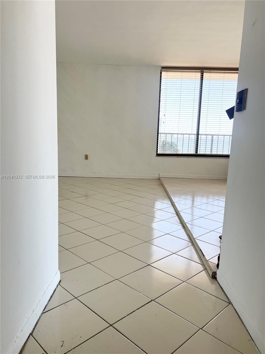 An interior view shows a room with light-colored diagonal floor tiles and a large window — 7899 NE Bayshore Ct # 6A, Miami FL 33138, MIAMI, FL