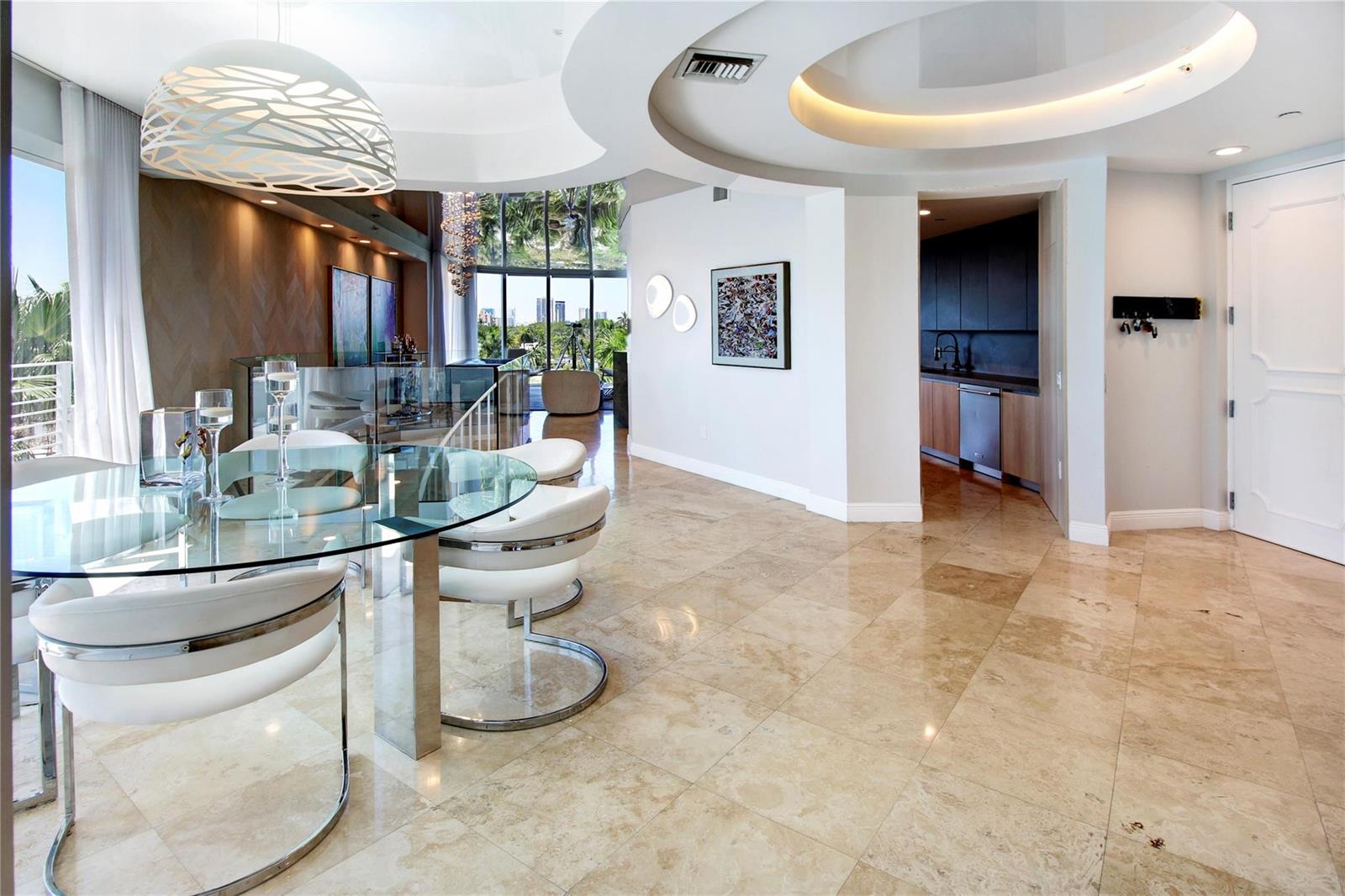 A dining area with a glass table and white chairs features marble floors and recessed lighting — 301 Hendricks Isle # 7, Fort Lauderdale FL 33301, FORT LAUDERDALE, FL