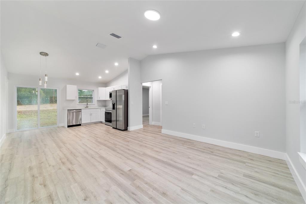 A bright open-concept kitchen and living area with gray walls and dark wood-look flooring — TBD SW 30TH STREET, OCALA, FL