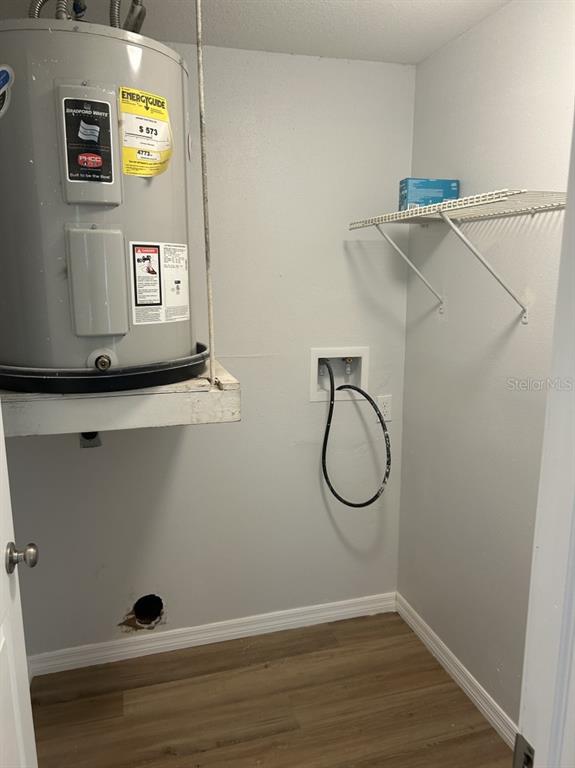 A utility closet features a water heater, a laundry hookup box, and a wire shelf — 121 LOBLOLLY COURT UNIT C, OLDSMAR, FL