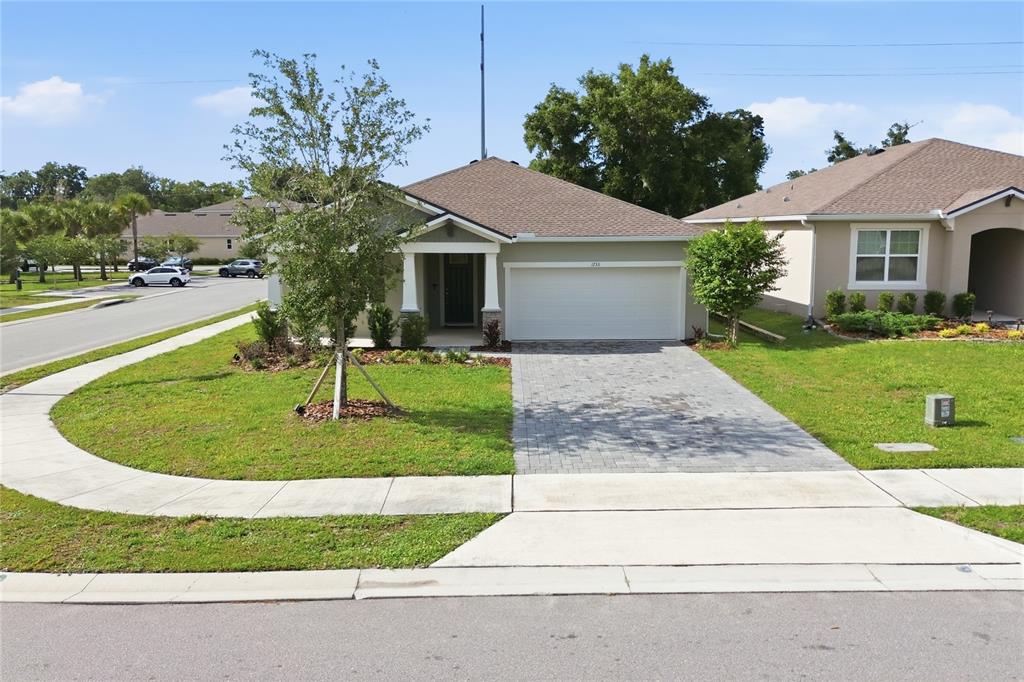 A single-story house with a paved driveway, two-car garage, and a small front porch — 1733 CARNELIAN STREET, DELAND, FL