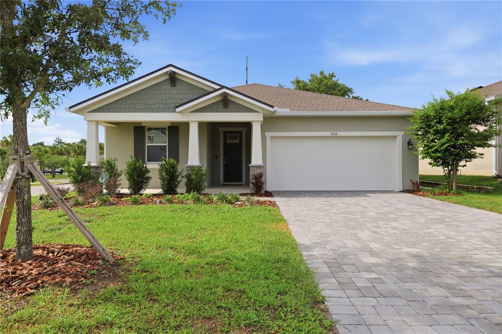 A single-story house with a green facade, a covered porch, and a paved driveway — 1733 CARNELIAN STREET, DELAND, FL