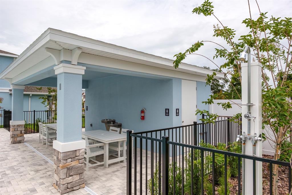 A covered outdoor patio features a dining table, a water fountain, and an exterior shower — 2520 MARIO WAY, CLEARWATER, FL