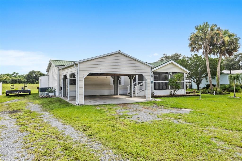 A single-story house with a large attached carport and a screened-in porch — 8945 SE 57TH DRIVE, OKEECHOBEE, FL