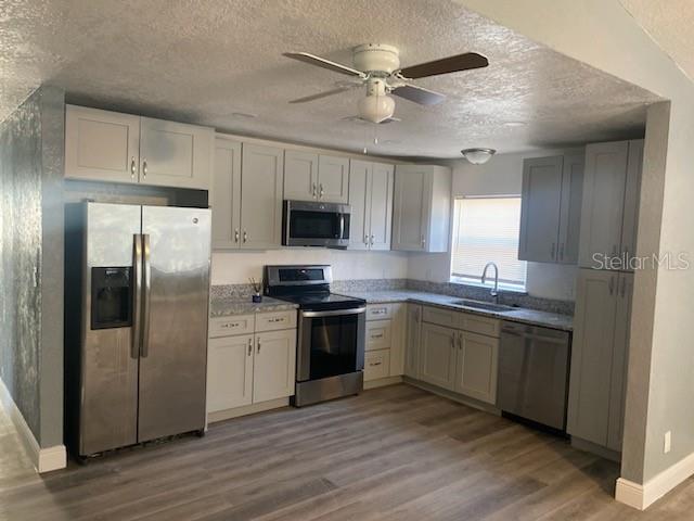 A kitchen features gray cabinets, stainless steel appliances, and light wood-look flooring — 724 GROVE AVENUE, ORLANDO, FL