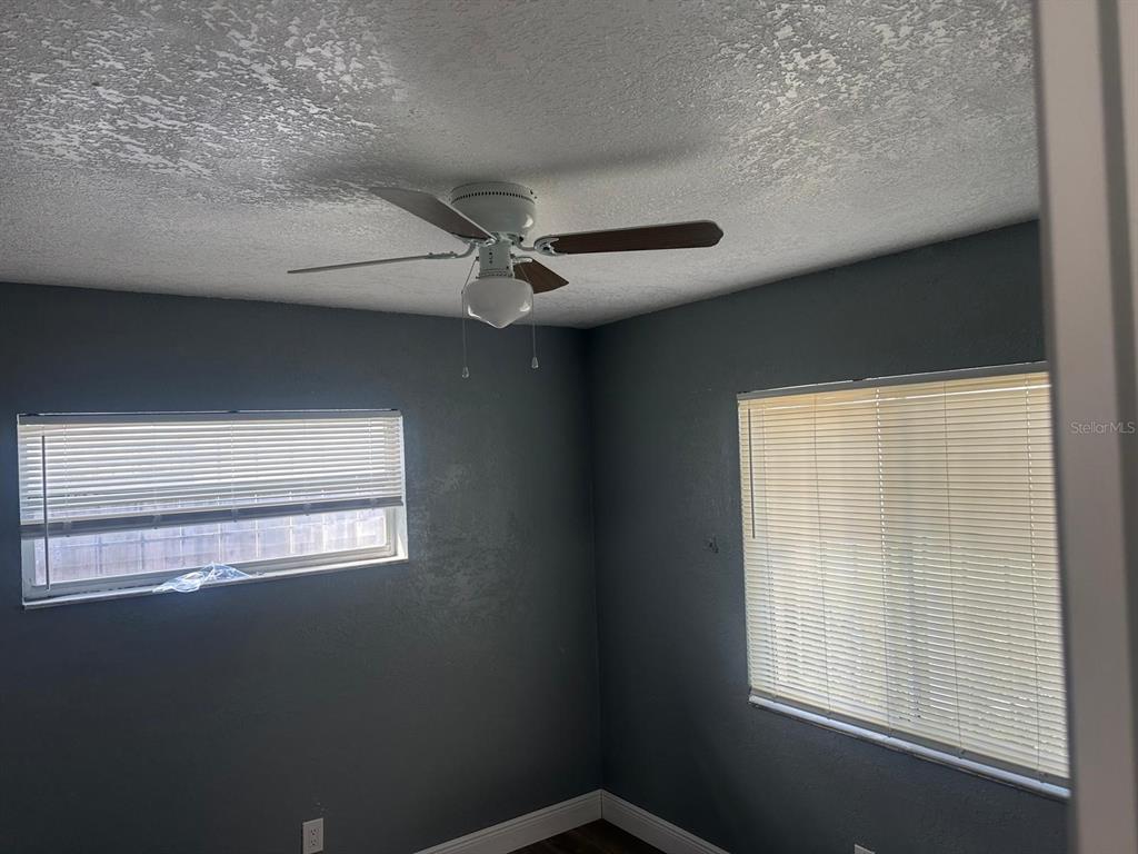 A bedroom with gray walls, two windows with blinds, and a white ceiling fan — 724 GROVE AVENUE, ORLANDO, FL