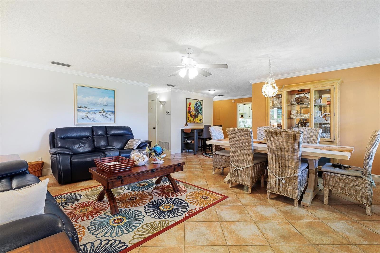 A living and dining area features tile floors, a floral rug, and wicker dining chairs — 63 Woodland Drive, Vero Beach FL 32962, VERO BEACH, FL