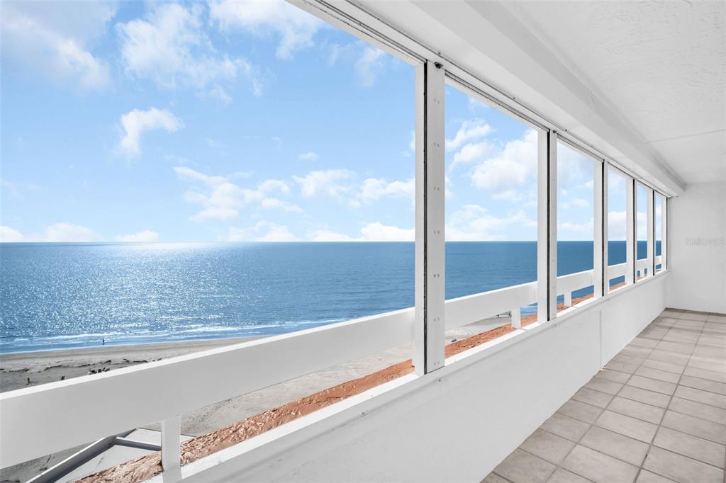 A tiled balcony overlooks the ocean through a series of large, white-framed windows — 17900 GULF BOULEVARD UNIT 12A, REDINGTON SHORES, FL
